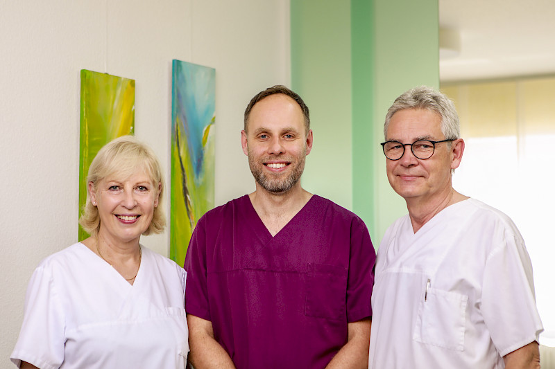 Gemeinsames Foto von Dr. Uta Hoffmann, Dr. Philipp Hoffmann (Fachzahnarzt für Oralchirurgie) und Dr. Uwe Hoffmann in der gemeinsamen Praxis.